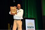 Brennan Washington holds his award plaque from the SOWTH steering committee members in recognition of world class leadership, advocacy, and field work.