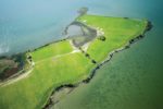 Aerial view of farm fields surrounded by water